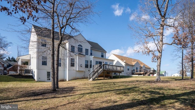 back of property featuring a residential view, a deck, stairs, and a lawn