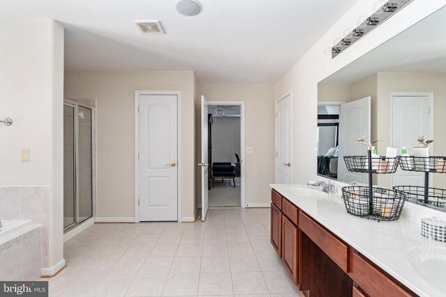 bathroom featuring a shower stall, tile patterned flooring, double vanity, and baseboards