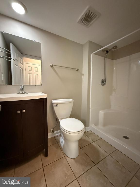 11503 Wilderness Park Dr, Spotsylvania, VA 22551 - bathroom featuring tile patterned floors, toilet, vanity, baseboards, and a shower