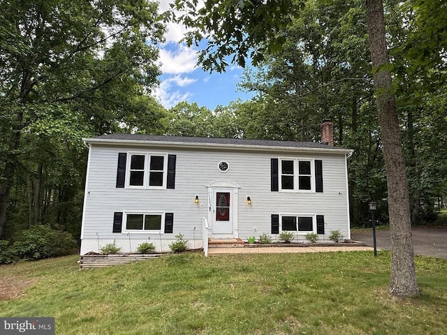 11503 Wilderness Park Dr, Spotsylvania, VA 22551 - raised ranch featuring a chimney, a front lawn, and entry steps