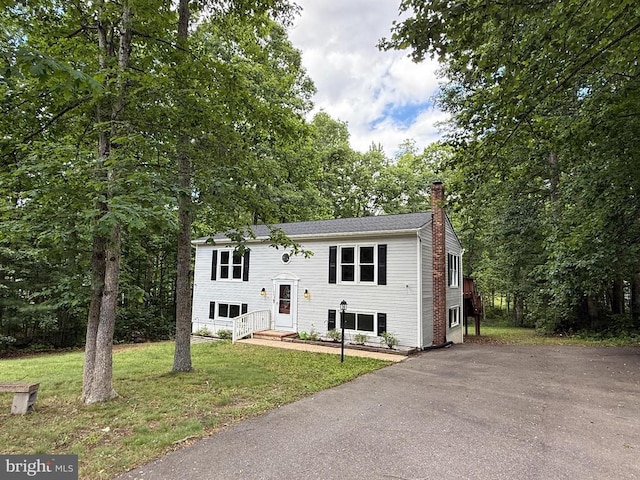 11503 Wilderness Park Dr, Spotsylvania, VA 22551 - raised ranch featuring a chimney, a front lawn, and asphalt driveway