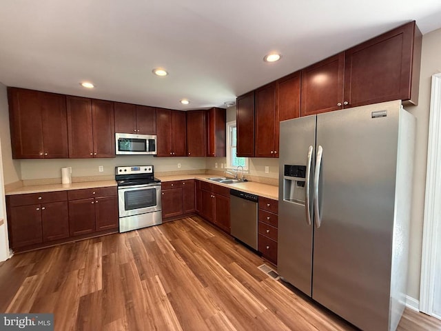 11503 Wilderness Park Dr, Spotsylvania, VA 22551 - kitchen featuring appliances with stainless steel finishes, wood finished floors, a sink, light countertops, and recessed lighting
