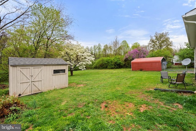 view of grassy yard featuring a storage unit and an outbuilding