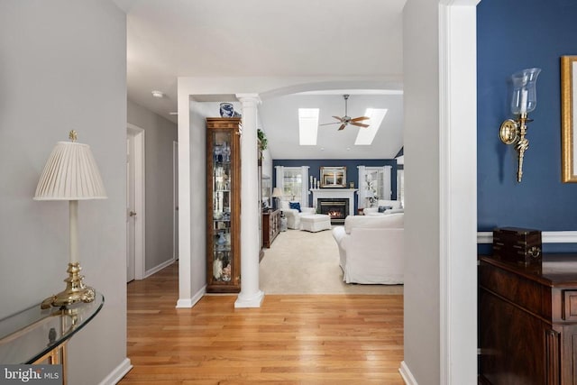 604 Mt Pleasant Dr, Locust Grove, VA 22508 - hallway with arched walkways, baseboards, light wood finished floors, and decorative columns