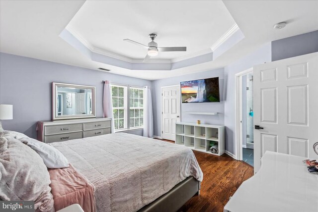 6915 Yeoman Ct, Fredericksburg, VA 22407 - bedroom featuring ornamental molding, a tray ceiling, dark wood-style floors, and a ceiling fan