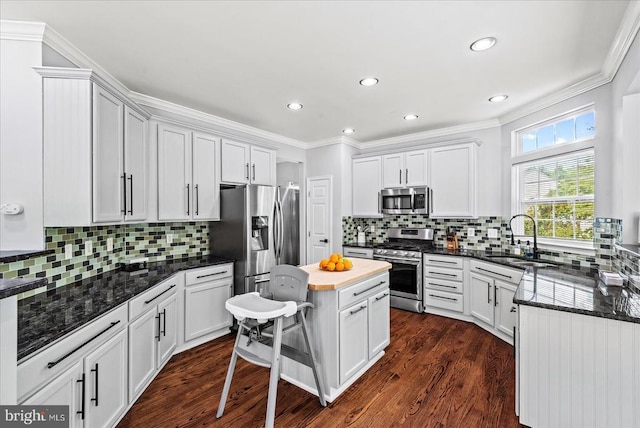 6915 Yeoman Ct, Fredericksburg, VA 22407 - kitchen featuring stainless steel appliances, a sink, decorative backsplash, crown molding, and dark wood-style floors