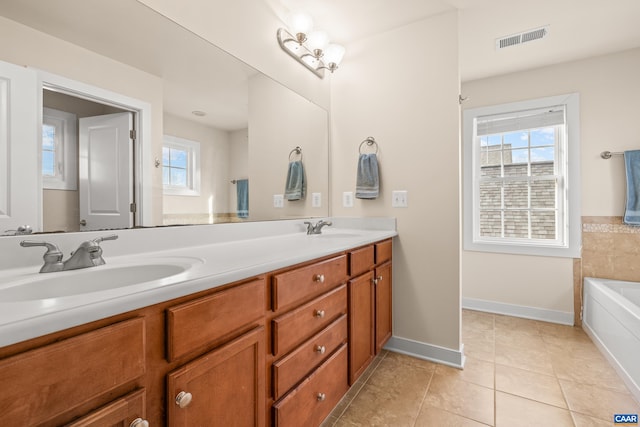 bathroom with a sink, a wealth of natural light, visible vents, and tile patterned floors