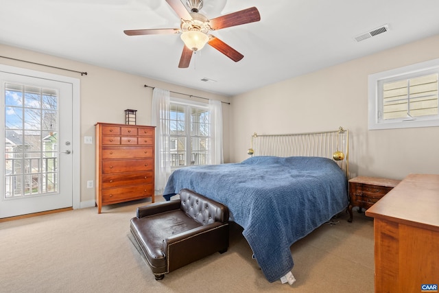 bedroom featuring baseboards, ceiling fan, visible vents, light colored carpet, and access to exterior