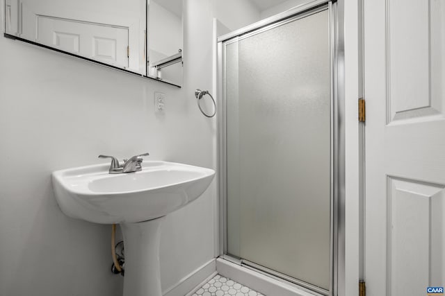 bathroom with a shower stall and baseboards