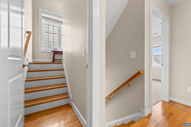 stairs with wood finished floors and baseboards