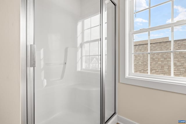 bathroom with a stall shower and baseboards