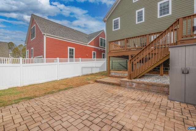 view of patio / terrace with stairway, fence, and a deck