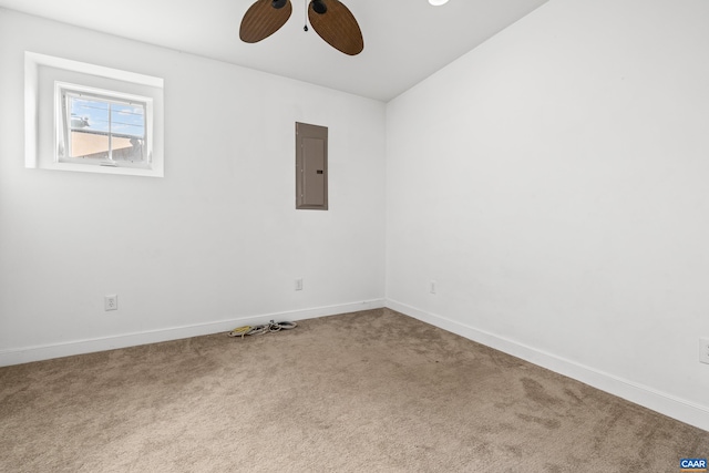 carpeted spare room featuring a ceiling fan, baseboards, and electric panel