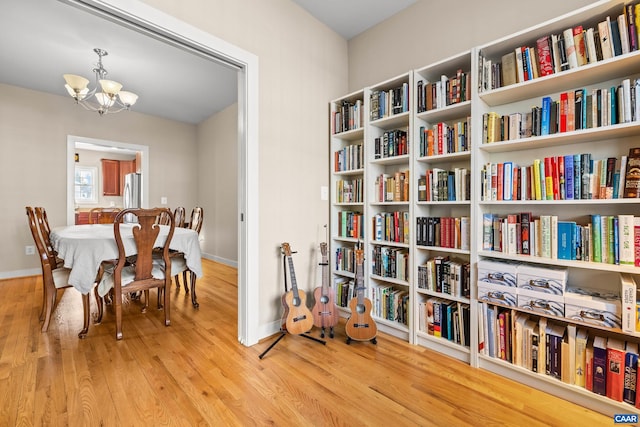 sitting room featuring a chandelier, baseboards, and wood finished floors