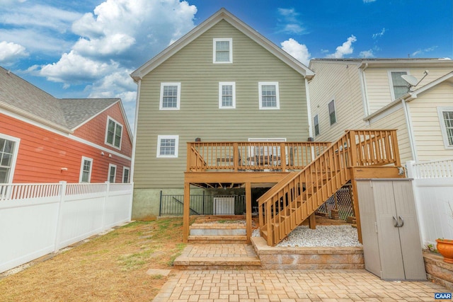 back of house featuring stairs, a wooden deck, and a fenced backyard