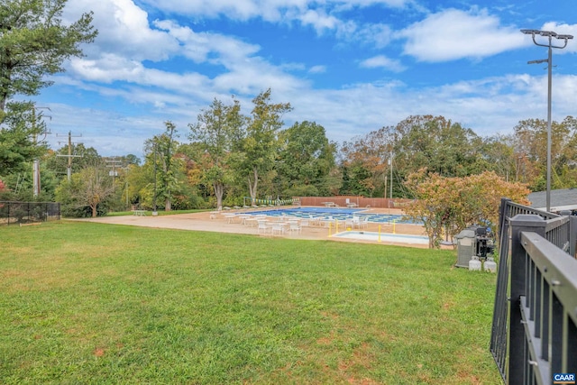 view of yard with fence and a community pool