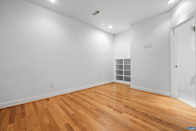 spare room featuring baseboards, recessed lighting, light wood-style flooring, and visible vents
