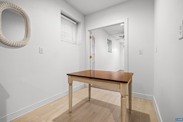 hallway featuring light wood-style flooring and baseboards