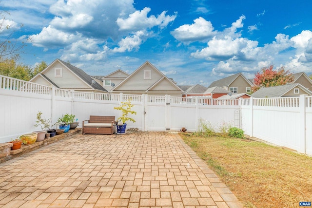 view of patio featuring a residential view, a fenced backyard, and a gate