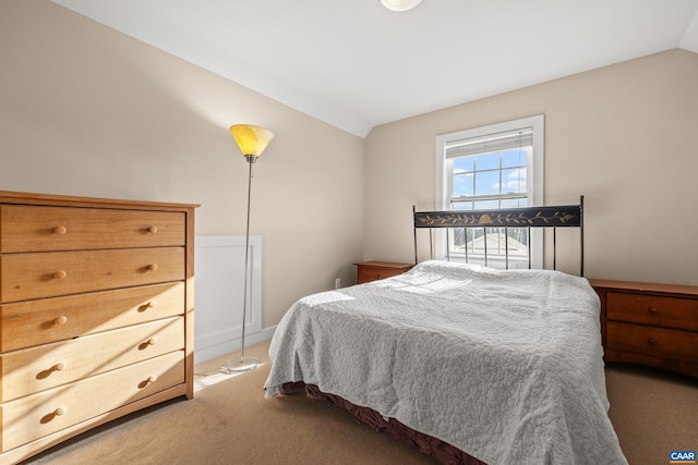 bedroom featuring vaulted ceiling and light carpet