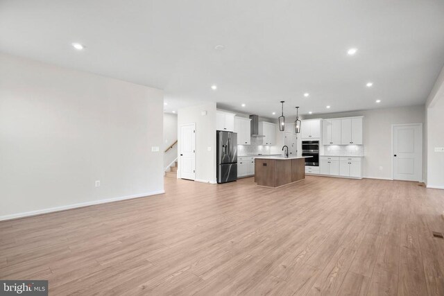 1 Blakely St, Fredericksburg, VA 22408 - unfurnished living room with a sink, light wood-type flooring, recessed lighting, baseboards, and stairway