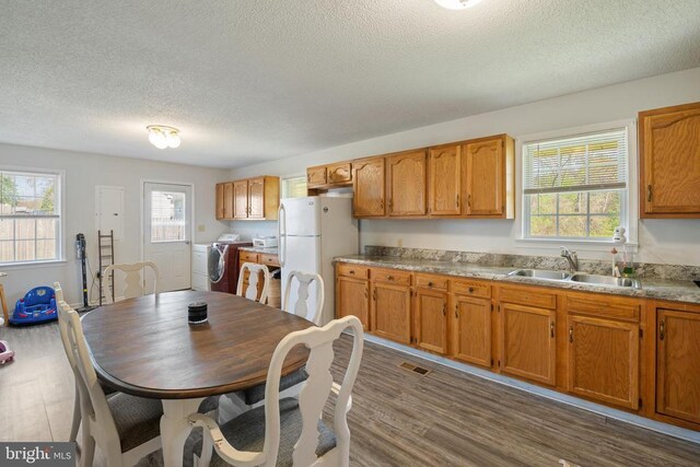 301 Charles St, Gordonsville, VA 22942 - kitchen with washing machine and dryer, a sink, freestanding refrigerator, a textured ceiling, and dark wood-style floors