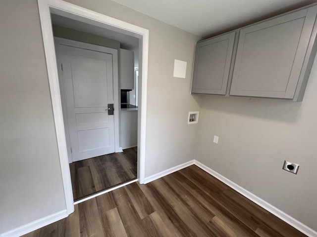 laundry area featuring electric dryer hookup, baseboards, dark wood-style floors, cabinet space, and washer hookup