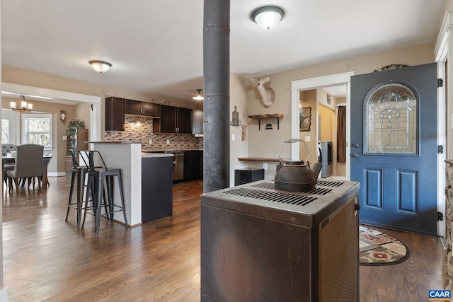 1481 Red Bird Dr, Stanardsville, VA 22973 - kitchen with tasteful backsplash, a breakfast bar, dark wood-style flooring, a chandelier, and dark brown cabinets