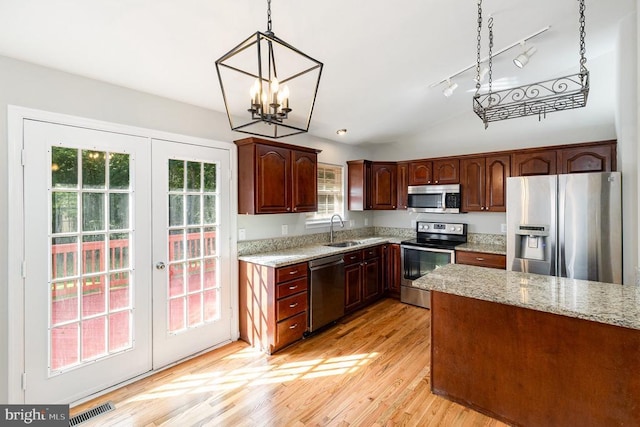7001 Aspen Ln, Spotsylvania, VA 22551 - kitchen with stainless steel appliances, a sink, french doors, hanging light fixtures, and light wood-style floors