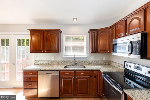 7001 Aspen Ln, Spotsylvania, VA 22551 - kitchen with appliances with stainless steel finishes, a sink, healthy amount of natural light, and light stone countertops