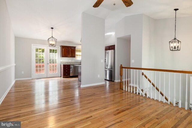 7001 Aspen Ln, Spotsylvania, VA 22551 - unfurnished living room featuring light wood finished floors, ceiling fan, baseboards, a chandelier, and vaulted ceiling