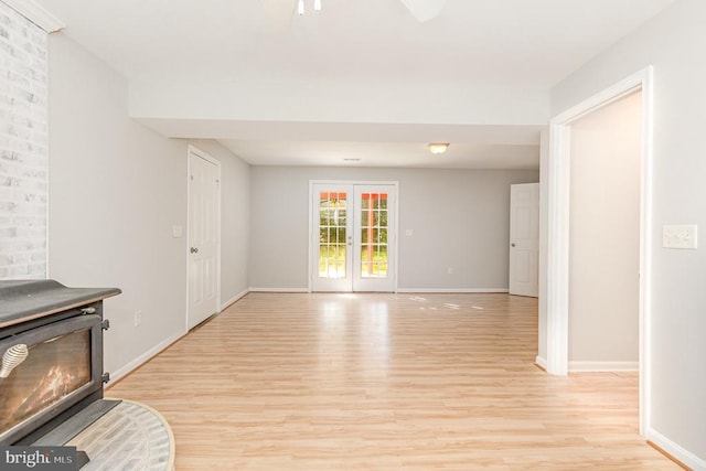 7001 Aspen Ln, Spotsylvania, VA 22551 - unfurnished living room featuring light wood finished floors, a ceiling fan, baseboards, and a wood stove