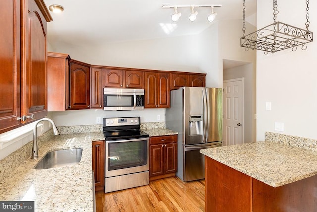 7001 Aspen Ln, Spotsylvania, VA 22551 - kitchen featuring stainless steel appliances, a sink, light wood-style flooring, light stone counters, and a peninsula