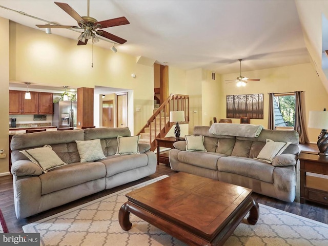  - living room featuring a ceiling fan, wood finished floors, stairway, and high vaulted ceiling