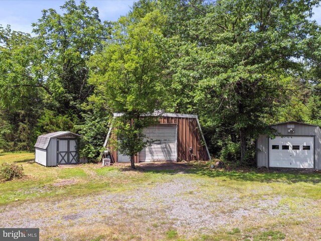  - view of grassy yard featuring an outbuilding and a detached garage