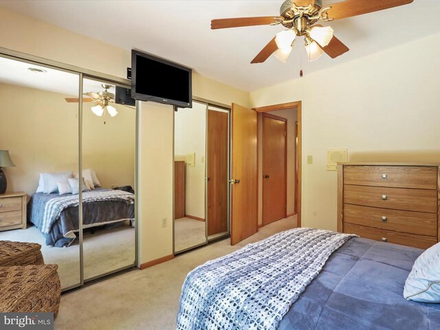  - bedroom with two closets, light carpet, and ceiling fan
