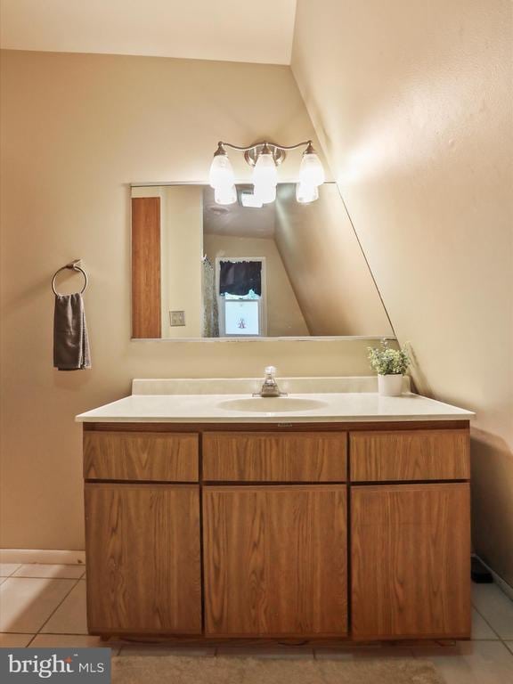 - bathroom with vanity, tile patterned floors, and lofted ceiling
