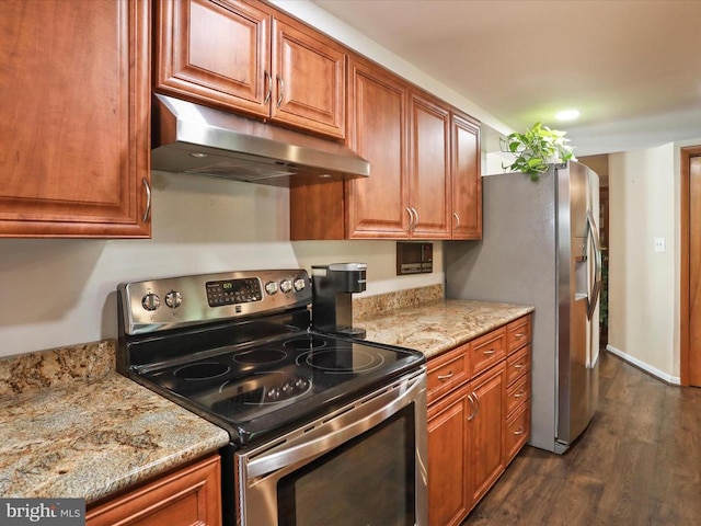  - kitchen with appliances with stainless steel finishes, under cabinet range hood, dark wood-style flooring, and brown cabinets