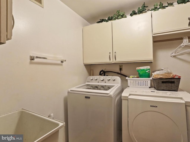  - washroom featuring cabinet space and washing machine and clothes dryer