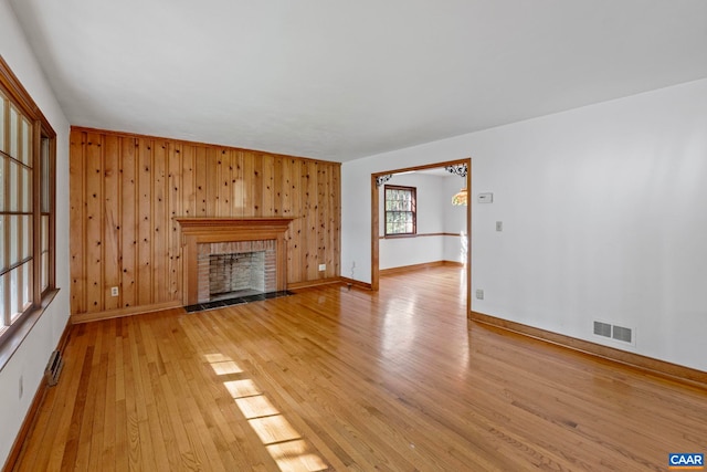 411 Westmoreland Ct, Charlottesville, VA 22901 - unfurnished living room with light wood-type flooring, a brick fireplace, and wood walls