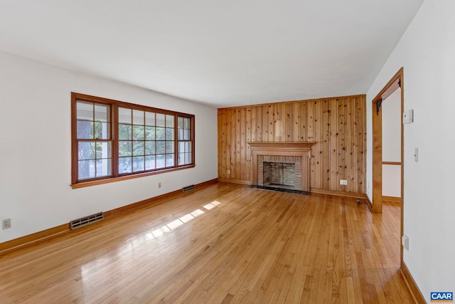 411 Westmoreland Ct, Charlottesville, VA 22901 - unfurnished living room with light wood-style flooring, wood walls, and a fireplace