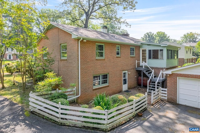 411 Westmoreland Ct, Charlottesville, VA 22901 - view of front facade with brick siding, a chimney, and a garage