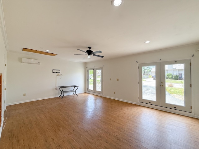 unfurnished room with french doors, light wood-type flooring, a ceiling fan, recessed lighting, and a wall mounted AC