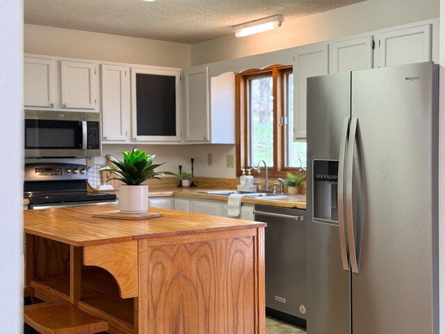 150 Falling Rock Dr, Stuarts Draft, VA 24477 - kitchen with appliances with stainless steel finishes, butcher block counters, a sink, white cabinets, and a textured ceiling