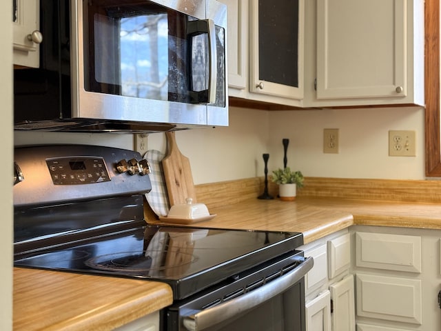 kitchen featuring appliances with stainless steel finishes, light countertops, and white cabinets