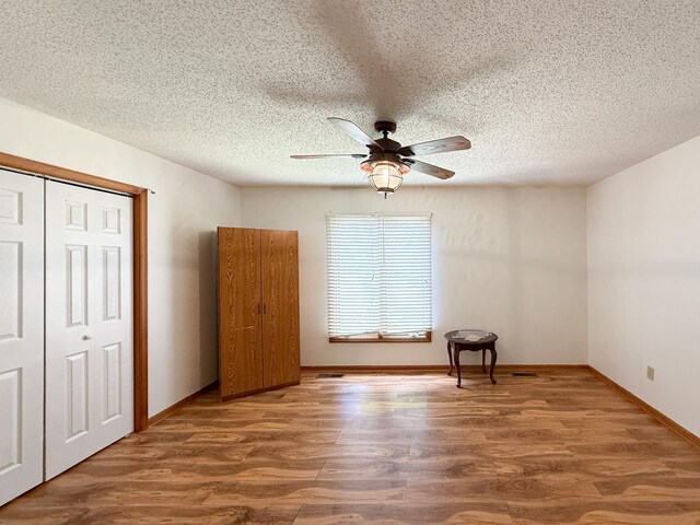 150 Falling Rock Dr, Stuarts Draft, VA 24477 - unfurnished bedroom with wood finished floors, a closet, a ceiling fan, baseboards, and a textured ceiling
