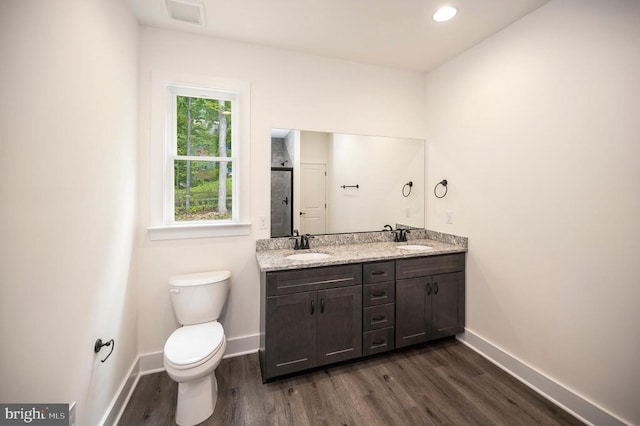 - full bath with wood finished floors, double vanity, and a shower