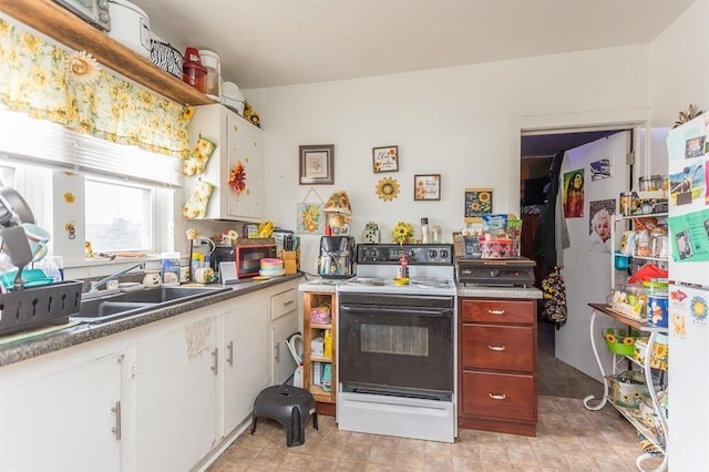 kitchen featuring white refrigerator, sink, white cabinets, and electric stove