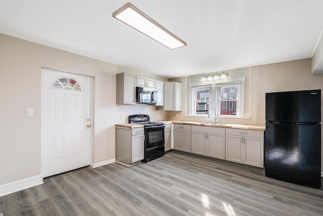 kitchen with gray cabinets, sink, light hardwood / wood-style flooring, and black appliances