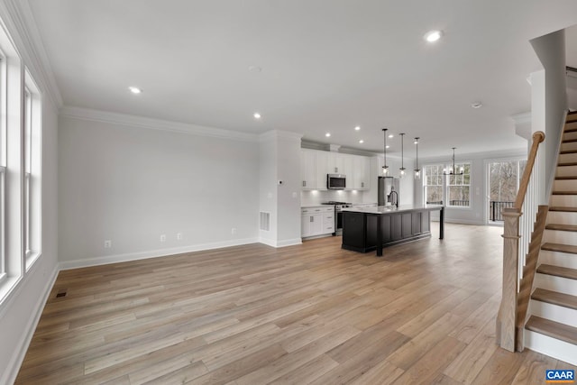 unfurnished living room with light wood finished floors, stairway, baseboards, and recessed lighting